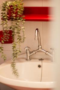 a bathroom sink with a faucet and a plant at ZeusPlace Park View Apartment Paralia Katerini in Paralia Katerinis