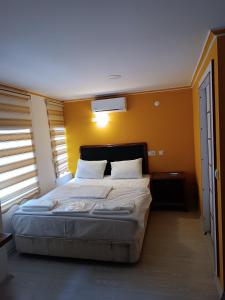 a bedroom with a large bed with yellow walls at TAG Pansiyon in Antalya +16 photos