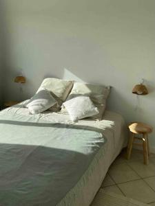 ein Schlafzimmer mit einem Bett mit Kissen und einem Stuhl in der Unterkunft Bel appartement idéalement situé in Valence