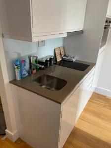 a kitchen with a sink and a counter top at Vibrant flat in the city centre in Slough