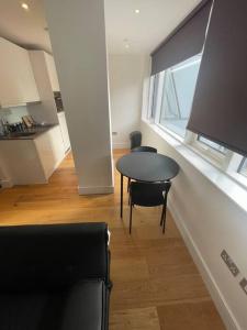 a room with a table and chairs and a window at Vibrant flat in the city centre in Slough