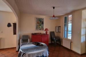 ein Schlafzimmer mit einem Bett, einem roten Schrank und einem Fenster in der Unterkunft Maison de campagne vue Étang de Thau ! in Frontignan