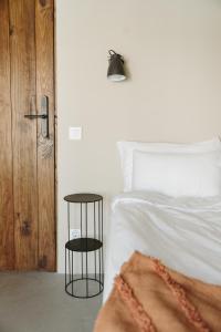 a bedroom with a white bed and a black end table at Rooftop Guesthouse Alvor in Alvor