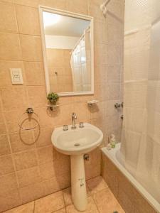 een badkamer met een wastafel, een spiegel en een douche bij Monoambiente Elegante y Economico in San Salvador de Jujuy