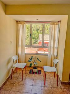 een woonkamer met 2 stoelen en een raam bij Monoambiente Elegante y Economico in San Salvador de Jujuy