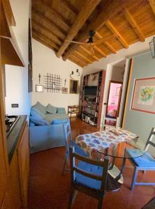 sala de estar con mesa y sofá azul en Appartamento chic Riomaggiore 5 Terre, en Riomaggiore