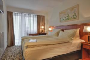 um quarto com uma cama grande num quarto de hotel em Hotel Condor em Munique