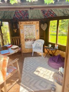 a room with a chair and a table and windows at Highgate Mountain in Pembrokeshire