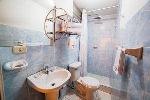 a blue tiled bathroom with a sink and a toilet at Principe III in Cusco