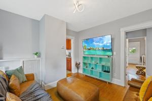 a living room with a couch and a flat screen tv at Cozy house close to Brandeis, Bentley, Moody St in Waltham