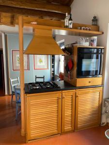 a kitchen with a stove and a microwave at Appartamento chic Riomaggiore 5 Terre in Riomaggiore