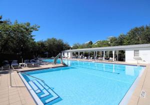 a large swimming pool with chairs and a building at Spice in Santa Rosa Beach