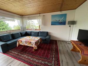 a living room with a blue couch and a table at Haus Silverfern in Förolach