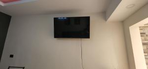 a flat screen tv on top of a white wall at Altea Hostal in Santa Ana