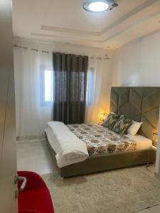 een slaapkamer met een bed in een kamer met gordijnen bij Go to the top in Dakar
