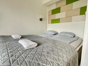 バラトンフレドにあるBonita Apartman & Garageのベッドルーム1室(ベッド2台、タオル付)