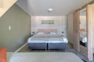 een slaapkamer met een bed en een spiegel bij De Hoog Velden 14 in Neerpelt