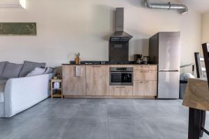 een keuken met een koelkast en een bank in een kamer bij De Hoog Velden 14 in Neerpelt
