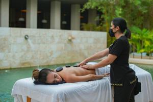 a woman getting a massage from a masseur at Paradisus La Perla - Adults Only All Inclusive in Playa del Carmen