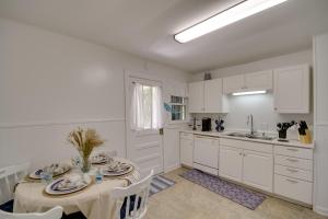 cocina blanca con mesa y fregadero en Pet-Friendly Retreat in Gulfport Less Than 1 Mi to Beach!, en Gulfport