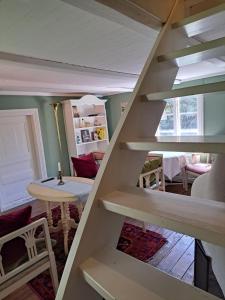 uma escada numa sala de estar com uma mesa em Malistorpets Rosor em Varberg