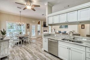 a kitchen with white cabinets and a dining room at Sandy's Seacrest in Inlet Beach