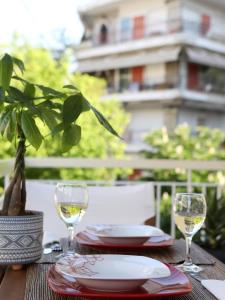 a table with two glasses of white wine on it at Psimithefto Luxury Apartments in Thessaloniki +60 photos