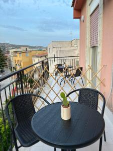 d'une table et de chaises noires sur le balcon. dans l'établissement Marea affittacamere, à Porto Empedocle