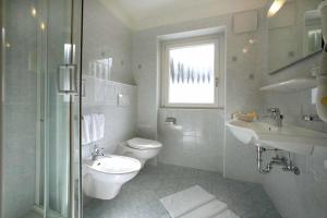 a bathroom with a toilet and a sink and a shower at Hotel Else in Selva di Val Gardena
