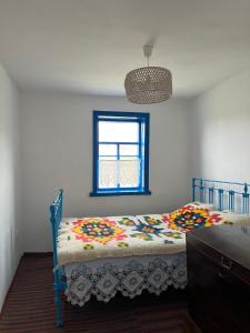 1 dormitorio con 1 cama con edredón y ventana en Бабусина хатка, en Leplyavo