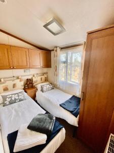 ペンブルックシャーにあるHighgate Mountainのベッド2台と窓が備わる小さな客室です。