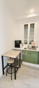 - une cuisine avec une table, un évier et un comptoir dans l'établissement Le petit havre de paix, Proche Paris-Disney-Asterix-Aéroport CDG, à Les Pavillons-sous-Bois