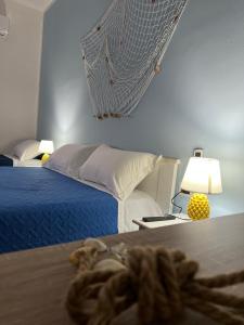 - une chambre avec un lit et une table avec une lampe dans l'établissement Marea affittacamere, à Porto Empedocle