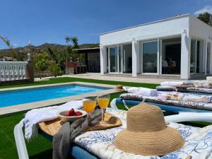 a table with a straw hat sitting next to a pool at Entre montañas in Árchez