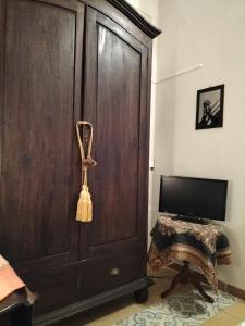 a large wooden cabinet in a room with a television at La Villa del Conte in Scicli