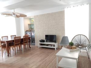 uma sala de estar com uma mesa de jantar e uma televisão em La Casa Rosa em Opoul-Périllos