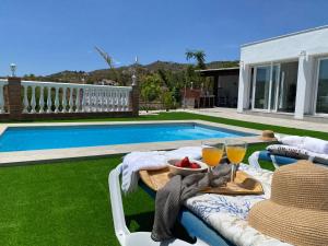 a table with two glasses of wine next to a swimming pool at Entre montañas in Árchez
