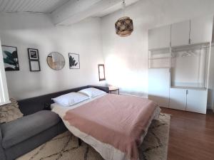 um quarto com uma cama e um sofá em La Casa Rosa em Opoul-Périllos