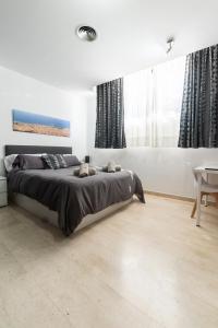 a bedroom with a large bed and a table at Apartament Granollers Up Live I in Granollers