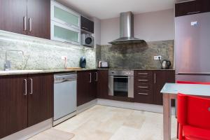 a kitchen with wooden cabinets and a counter top at Apartament Granollers Up Live I in Granollers