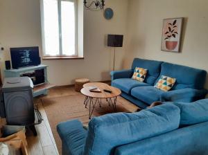 - un salon avec un canapé bleu et une table dans l'établissement Ker Yaël – Maison familiale avec grand jardin à 5min de la plage Saint Jean du doigt, à Saint-Jean-du-Doigt