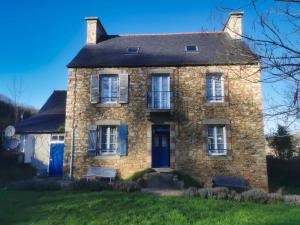 Cette ancienne maison en pierre est dotée de portes et de fenêtres bleues. dans l'établissement Ker Yaël – Maison familiale avec grand jardin à 5min de la plage Saint Jean du doigt, à Saint-Jean-du-Doigt