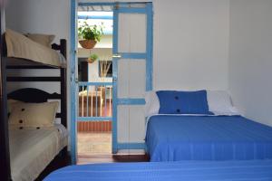 a bedroom with two bunk beds and a door to a balcony at Hostal Bosque de Niebla in Salento