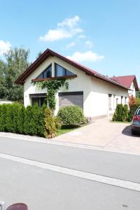 a white house with a car parked in front of it at FeWo Sulzer Siedlung Erfurt in Erfurt