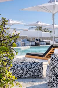 a pool with lounge chairs and an umbrella at Irene's Residence in Mikonos