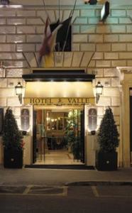 a hotel entrance with two potted trees in front of it at Hotel Valle in Rome