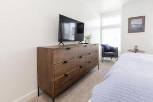a bedroom with a dresser with a television on it at Brand New Garden City 3BR 2BA BOAT PARKING in Garden City