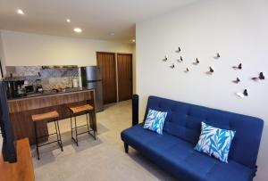 Increible departamento #5 في كانكون: غرفة معيشة مع أريكة زرقاء ومطبخ