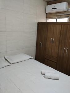 - une chambre avec un lit et 2 serviettes dans l'établissement Suites Jatiuca, à Maceió