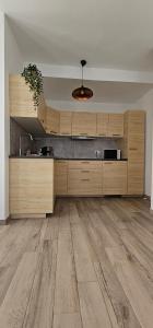 an empty kitchen with wooden cabinets and wood floors at Estrella de Mar in Tarajalejo